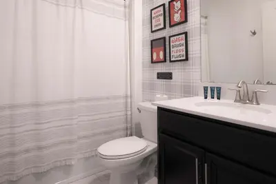 a white bathroom with a toilet and a sink at Fantasy Stay in 5 bed at Storey Lake in Kissimmee