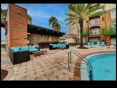 a patio with a pool and chairs and a building at Universal-Disney Dream 606S - 1 Bedroom in Orlando