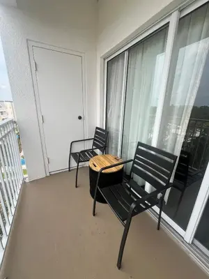 a balcony with two chairs and a table on a balcony at Universal-Disney Dream 606S - 1 Bedroom in Orlando