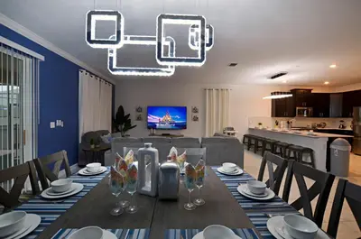 a dining room with a table and a living room at 4213 - Lakeside Retreat in Kissimmee