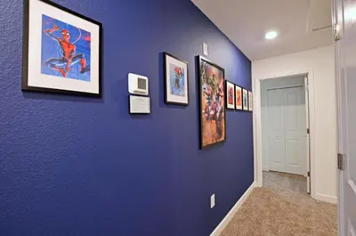 a hallway with a blue wall with pictures on it at 4213 - Lakeside Retreat in Kissimmee