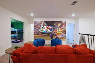 a living room with a red couch and blue chairs at 4213 - Lakeside Retreat in Kissimmee