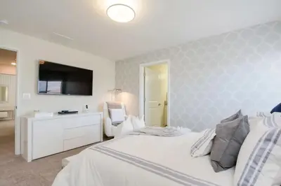 a bedroom with a white bed and a tv at Viva o Luxo – 5 Quartos e Piscina no Resort in Kissimmee