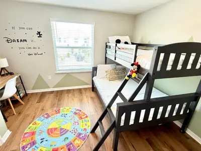 a small bedroom with a bunk bed and a desk at Boho retreat close to Disney! in Kissimmee