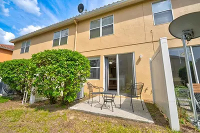 a house with a table and chairs in front of it at Comfy Townhome Minutes from Disney in Orlando