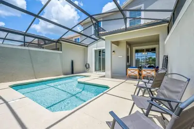 a swimming pool with chairs and a house at Férias Perfeitas! Casa 4Q+Piscina perto Disney in Kissimmee