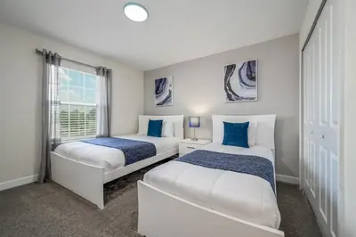 two beds in a room with a window at Férias Perfeitas! Casa 4Q+Piscina perto Disney in Kissimmee