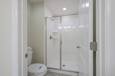 a white bathroom with a shower and a toilet at Férias Perfeitas! Casa 4Q+Piscina perto Disney in Kissimmee