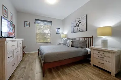 a bedroom with a bed and a dresser and a television at Spring Break Awaits Disney Close Pool Slides Fun in Orlando