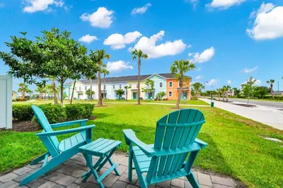 two blue chairs sitting on a patio in front of a house at Cheerful Villa Near Disney With Margaritaville Resort And Island H20 Waterpark Access - 2913Cs in Orlando