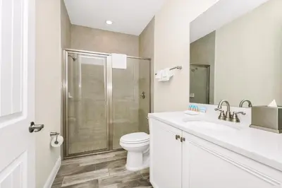 a white bathroom with a toilet and a shower at Cheerful Villa Near Disney With Margaritaville Resort And Island H20 Waterpark Access - 2913Cs in Orlando