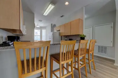 a kitchen with four chairs and a table in it at Cozy Vacation Retreat in Fiesta Key Community in Kissimmee