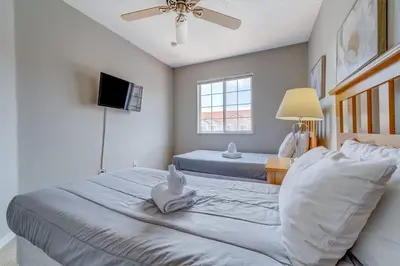a bedroom with two beds and a flat screen tv at Cozy Vacation Retreat in Fiesta Key Community in Kissimmee