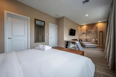 a bedroom with a white bed and a living room at Elegant Orlando Getaway Close To Disney in Kissimmee