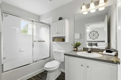 a white bathroom with a toilet and a sink at Family Escape Near Disney Serene Retreat in Terra Verde Resort in Kissimmee