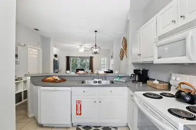 a kitchen with white cabinets and a sink at Family Escape Near Disney Serene Retreat in Terra Verde Resort in Kissimmee