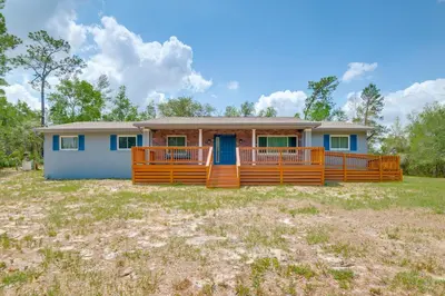 a house with a large deck in a yard at 15 Mi to Dtwn Orlando Spacious Family Home in Orlando