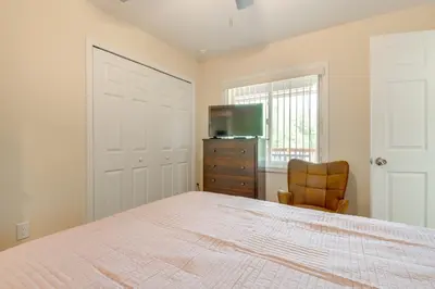 a bedroom with a bed and a tv and a chair at 15 Mi to Dtwn Orlando Spacious Family Home in Orlando