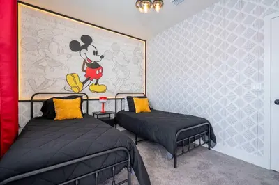 two beds in a room with a mickey mouse mural at Family Friendly w Pool near Disney at Serenity 1420 in Orlando