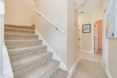 a staircase in a home with white walls and carpet at 10 Mi to Disney Parks Resort Retreat with Patio in Kissimmee