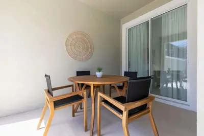 a dining room with a wooden table and chairs at Townhome 4Q Storey Lake c/ Piscina Privada in Kissimmee