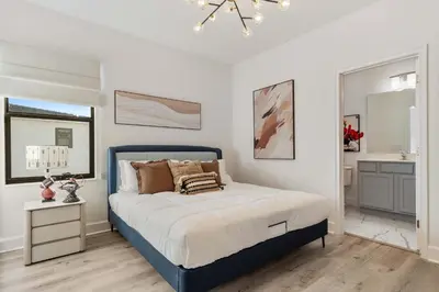a bedroom with a blue bed and a bathroom at Grand 15-Bedroom Villa -Magical Themes, Pool & Game Loft, Lakeview in Kissimmee