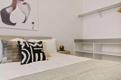 a bed with white sheets and pillows in a bedroom at Grand 15-Bedroom Villa -Magical Themes, Pool & Game Loft, Lakeview in Kissimmee