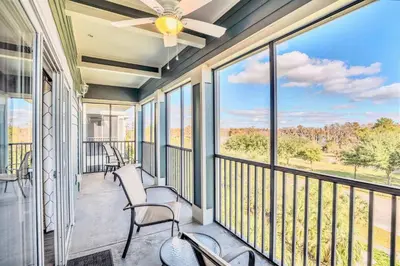 a balcony with chairs and a ceiling fan at Upstay Modern 3BR Getaway w Pool in Orlando
