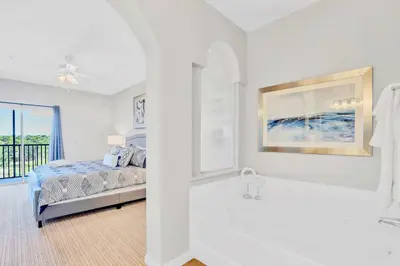 a white bedroom with a bed and a bath tub at Upstay Modern 3BR Getaway w Pool in Orlando
