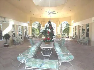 a lobby with green chairs and a table with flowers at Water Park & Fantastic Pool only Minutes To Walt Disney World's Front Gate!!! in Orlando