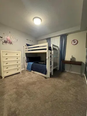 a bedroom with a white bunk bed and a dresser at 2 Bedrooms Apartment in Storey Lake in Kissimmee