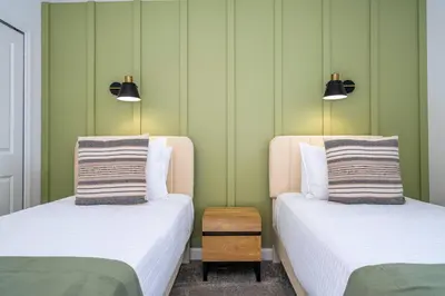 two beds in a room with green walls at Stylish Home & Free Resort Access 2420 in Kissimmee