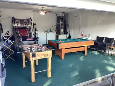 a room with a ping pong table in a garage at Plutospad in Orlando