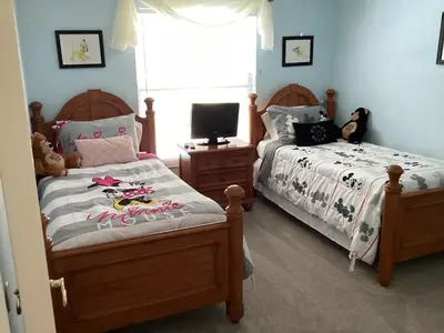 a bedroom with two beds and a tv in it at Plutospad in Orlando