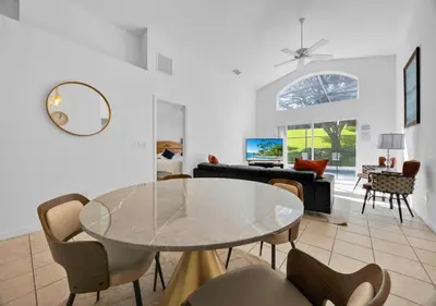 a living room with a glass table and chairs at Spacious Emerald Home - Pool and Lanai Near Disney in Kissimmee