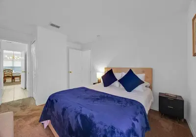 a bedroom with a large bed with blue pillows at Spacious Emerald Home - Pool and Lanai Near Disney in Kissimmee