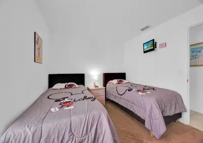 two beds in a white room with two beds sidx sidx sidx at Spacious Emerald Home - Pool and Lanai Near Disney in Kissimmee