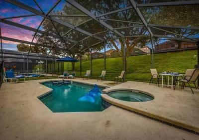 a swimming pool with a tent with chairs and a table at Spacious Emerald Home - Pool and Lanai Near Disney in Kissimmee