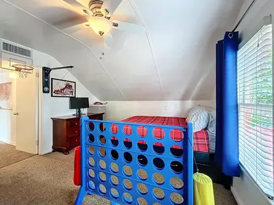 a childs bedroom with a blue crib and a ceiling fan at 1920s Rustic Cabin, 20 Min to Disney and Nightlife in Orlando