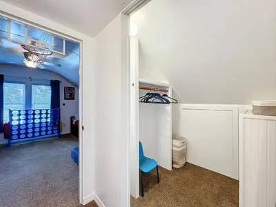 a room with a hallway with a blue chair in it at 1920s Rustic Cabin, 20 Min to Disney and Nightlife in Orlando