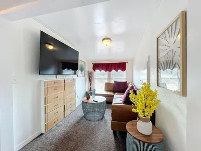 a living room with a couch and a table at 1920s Rustic Cabin, 20 Min to Disney and Nightlife in Orlando