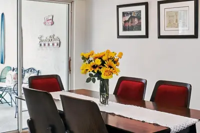 a dining room with a table with yellow flowers in a vase at Resort Fun Star Wars Toy Story Rooms Near Disney in Kissimmee
