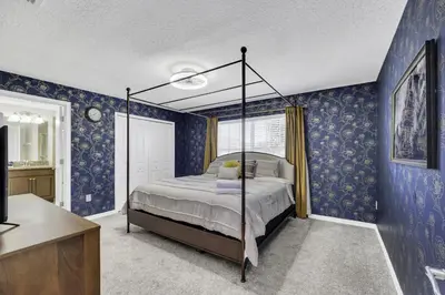 a bedroom with a canopy bed in a room with blue wallpaper at Resort Fun Star Wars Toy Story Rooms Near Disney in Kissimmee
