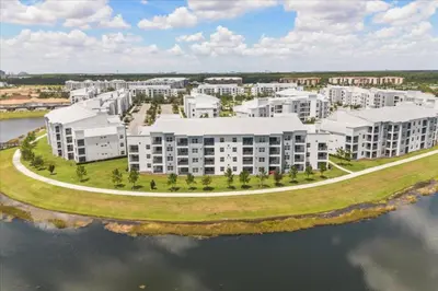 an aerial view of an apartment complex next to the water at 3 Bedrooms 2 Bathrooms Storey Lake 3141-306 in Kissimmee