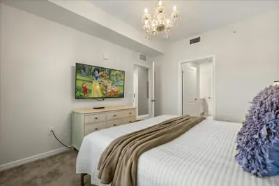 a bedroom with a bed and a tv on the wall at 3 Bedrooms 2 Bathrooms Storey Lake 3141-306 in Kissimmee