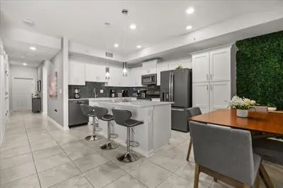a kitchen with white cabinets and a table and chairs at 3 Bedrooms 2 Bathrooms Storey Lake 3141-306 in Kissimmee