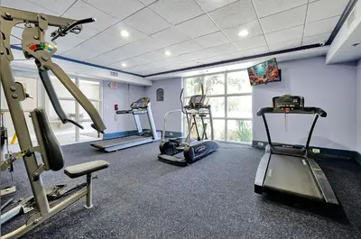 a gym with several tread machines in a room at Luxurious Condo near DisneyLand in Orlando