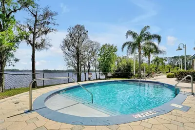 a swimming pool with trees and a body of water at Luxurious Condo near DisneyLand in Orlando