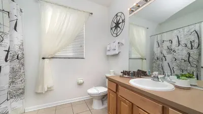 a bathroom with a sink and a toilet and a mirror at MNL2696 in Orlando
