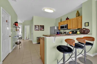 a kitchen with green walls and stools at a counter at MSW2549 in Orlando